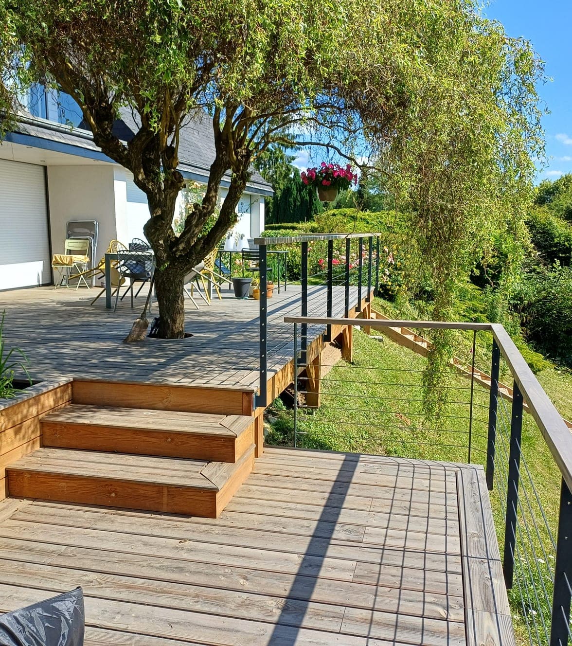 Terrasse en bois et son escalier, ouverte sur le jardin
